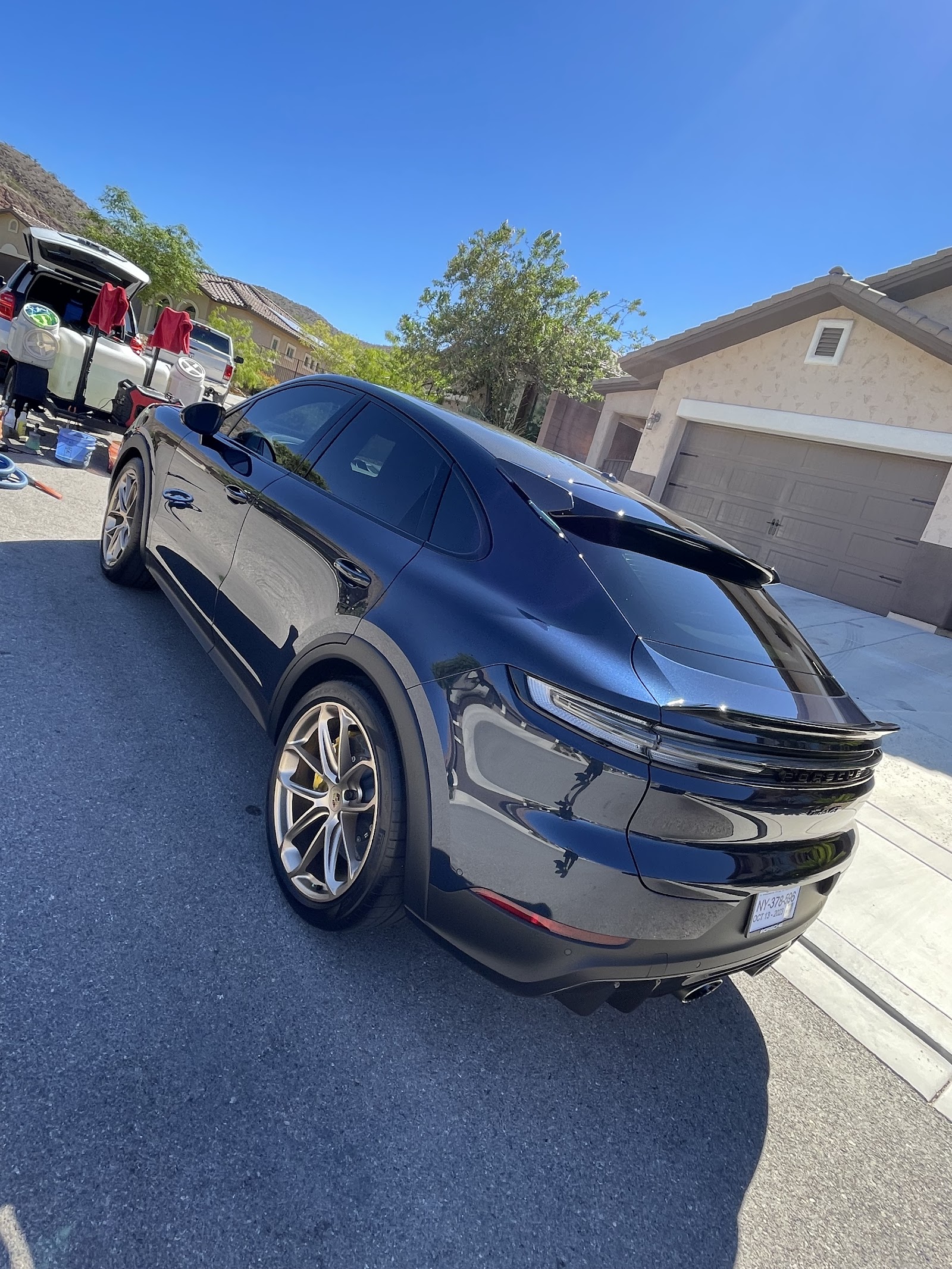 Detailed black Porsche Cayenne coupe, glossy rear-quarter view in a driveway