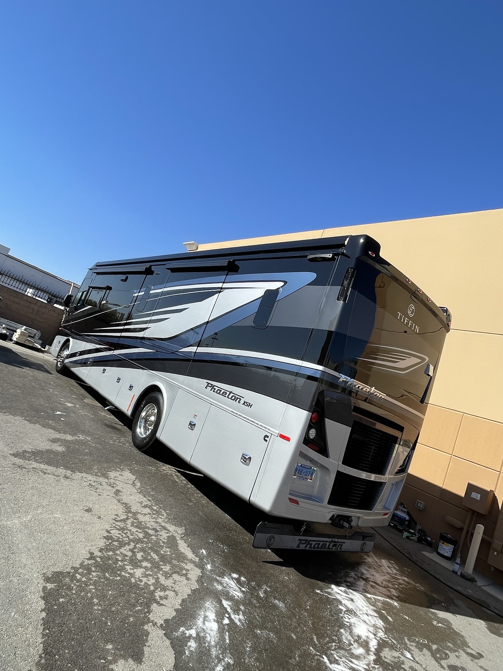 Detailed Tiffin Phaeton motorhome RV parked beside a commercial building